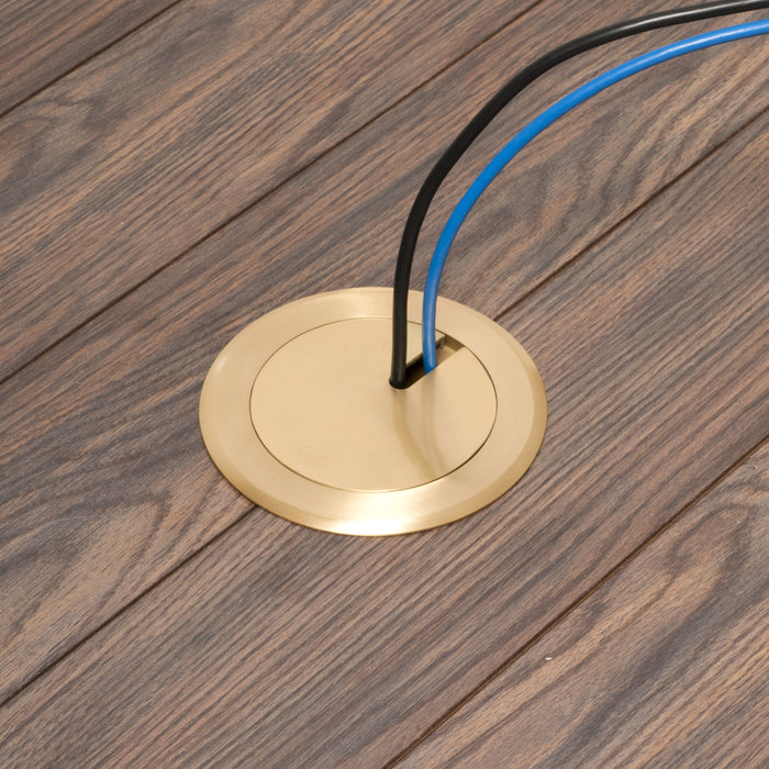 Arlington FLBC4560DMB brass floor box cover installed in a wood floor with low-voltage cable passing through the cover.