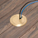 Arlington FLBC4560DMB brass floor box cover installed in a wood floor with low-voltage cable passing through the cover.